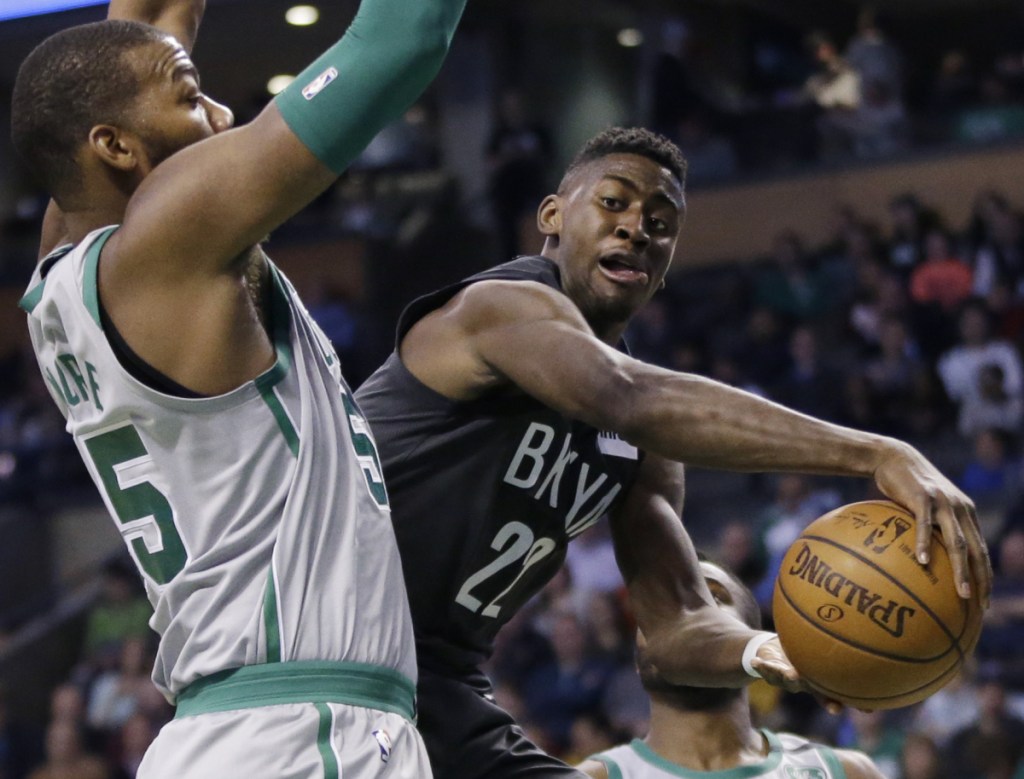 Nets guard Caris LeVert passes the ball around Celtics center Greg Monroe during Boston's 110-97 win on the final night of the regular season Wednesday.
