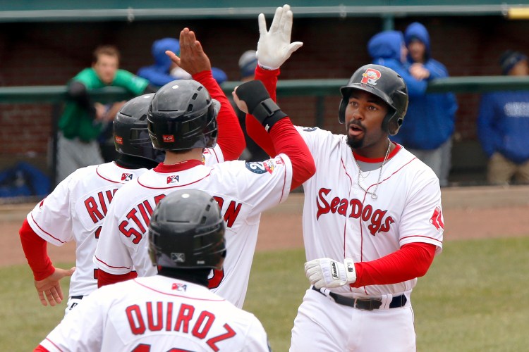 Portland's Josh Ockimey, right, celebrates with  Jeremy Rivera, Cole Sturgeon and Esteban Quiroz after driving them home with a grand slam in the seventh inning.