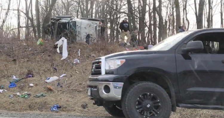 A sport utility vehicle lies on its side Tuesday morning up a hill from Interstate 95 in West Gardiner after a crash on the highway.