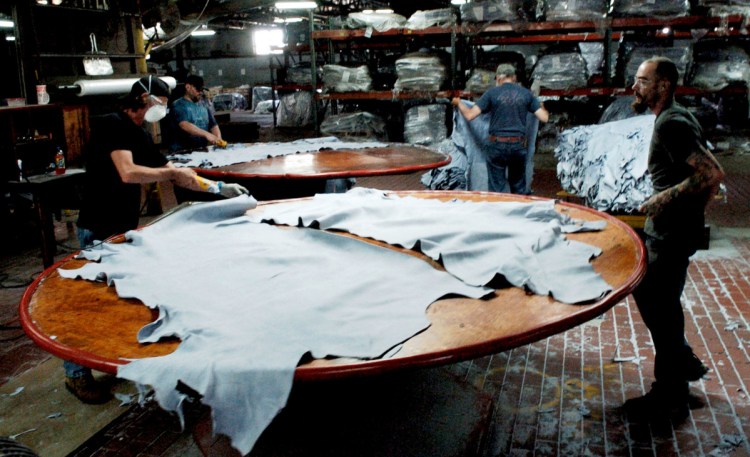 Employees at Tasman Leather Group work on July 20, 2016, at a station at the Hartland operation. The town of Hartland was awarded a $1.9 million grant to update water infrastructure, which is intended to benefit business in town.