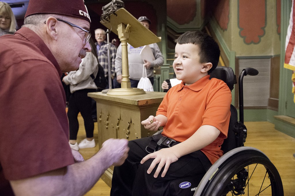 Sun Journal photo by Daryn Slover 
 Shriner Robert McWilliam of South Portland talks with special guest Alec Cabacungan after giving him a pin during the annual Maine Shrine Lobster Bowl Classic team meeting Sunday in Lewiston.