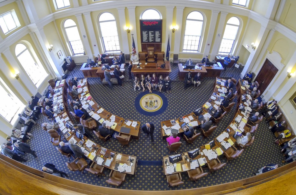 During a break in the morning session, leaders from both parties meet with Senate President Michael Thibodeau, R-Winterport, at the rostrum in the Senate chamber of the State House in Augusta.