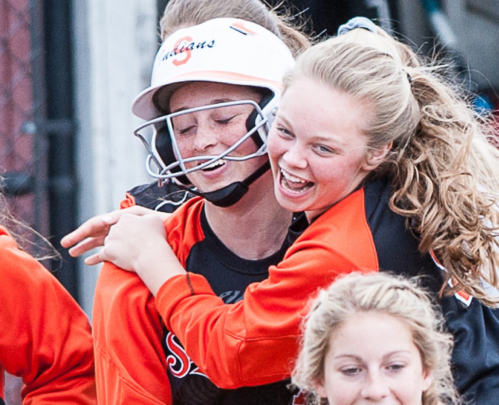 Skowhegan pitcher Ashely Alward, left, is mobbed by teammates after hitting a home run against Lewiston on Friday at Bates College. Alward also pitched a no-hitter for the Indians.