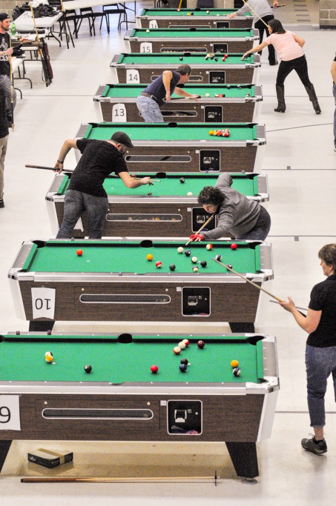The top four finalist teams in three divisions compete on many tables during a pool tournament on Sunday in the Augusta Armory.