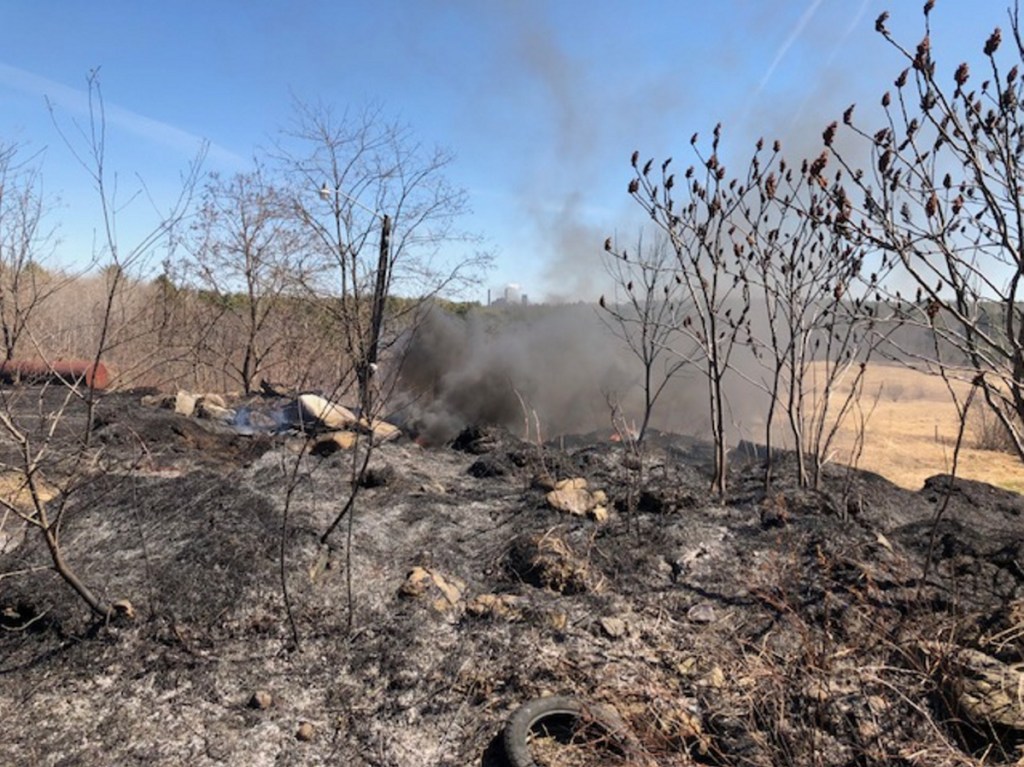 A stubborn tire fire burns Monday on Middle Road in Skowhegan, just 1.5 miles from the Sappi North America paper mill pictured in the background.