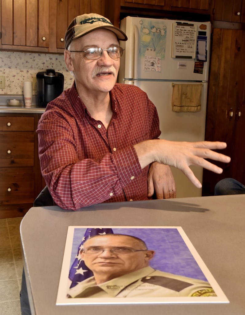 Tom Cole, brother of slain Somerset County Deputy Cpl. Eugene Cole, in photograph, talks with pride about his brother in Skowhegan on Sunday. "He was more than a brother and friend," Cole said. "He was a father figure."