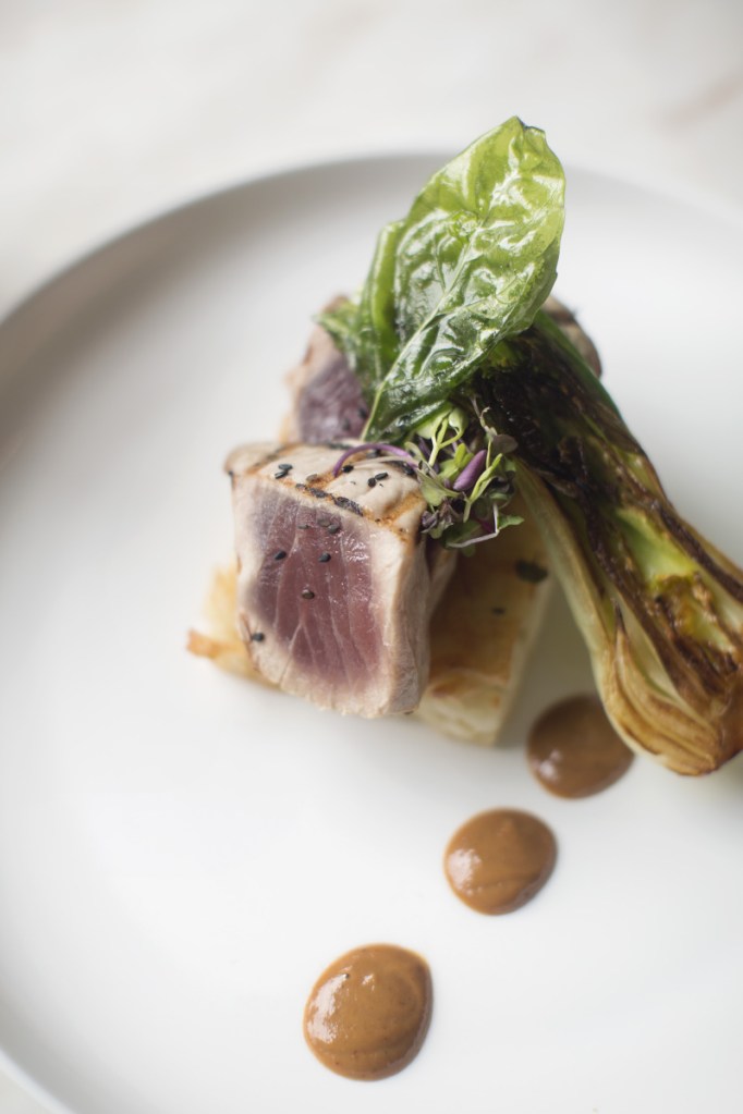 Yellowfin tuna with pan-fried udon noodles, peanut sauce, basil glaze and baby bok choy.