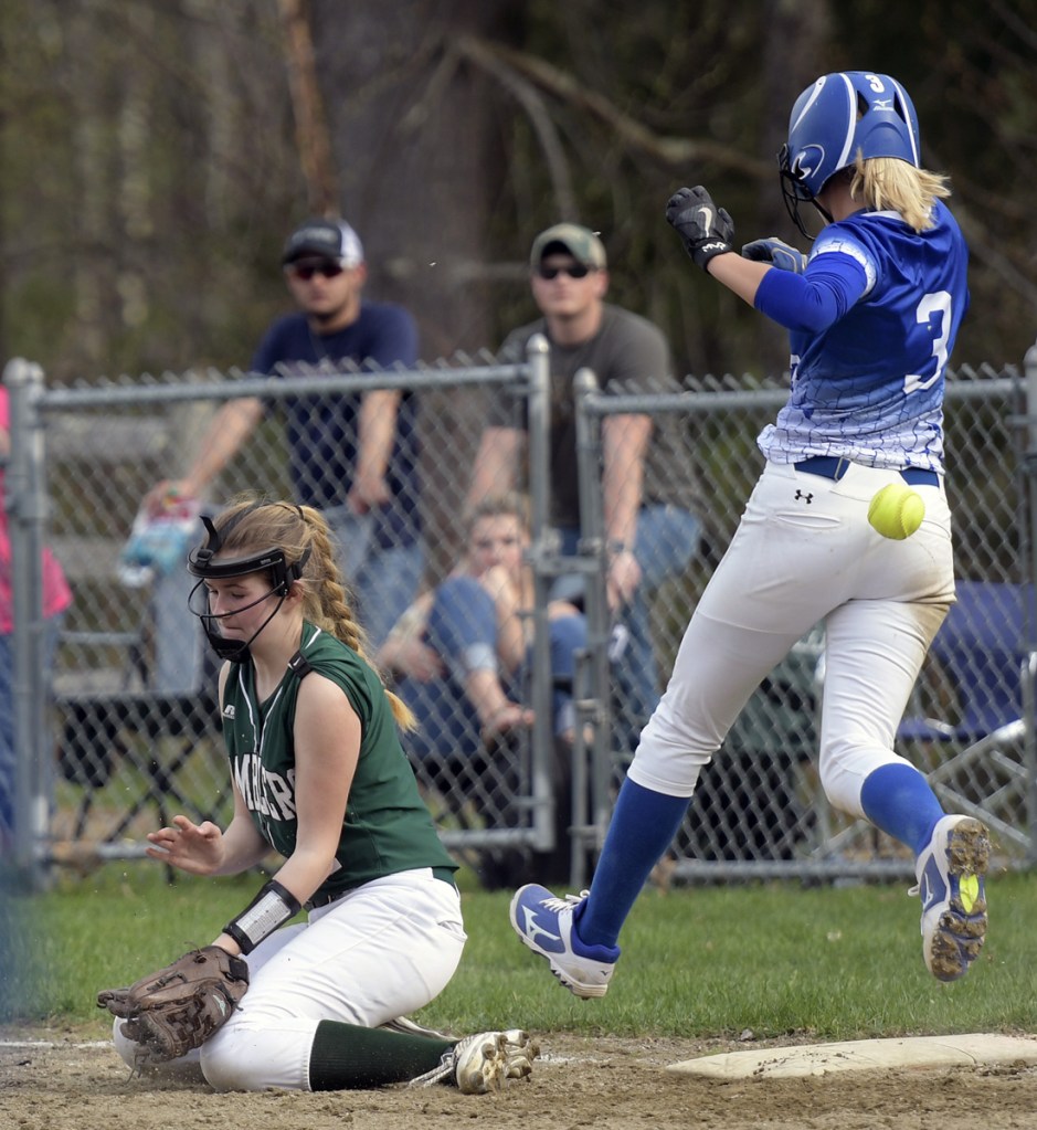 Winthrop's Bryana Baxter can't stop a throw to first as  Madison's Aishah Malloy tags during a softball game on Wednesday in Winthrop.