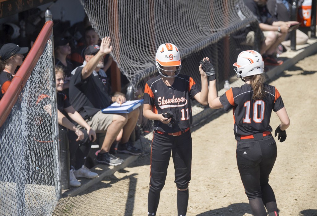 Skowhegan's Annie Cook (10) celebrates scoring a run against Messalonskee with teammate Alyssa Everett on Saturday in Skowhegan.