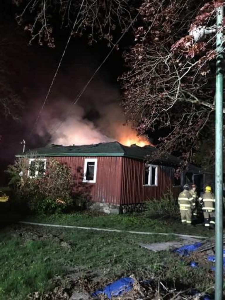 Firefighters work at the scene of a house fire that began late Friday night on Riverside Drive in Vassalboro,