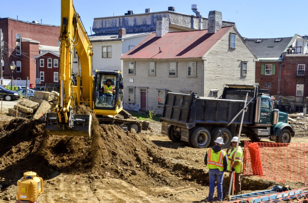 Workers from MainEx dig a basement hole at the corner of the Central and Second streets on May in Hallowell. The Dummer House, in background, will be moved there in a few weeks and the space on Dummer's Lane will become parking.