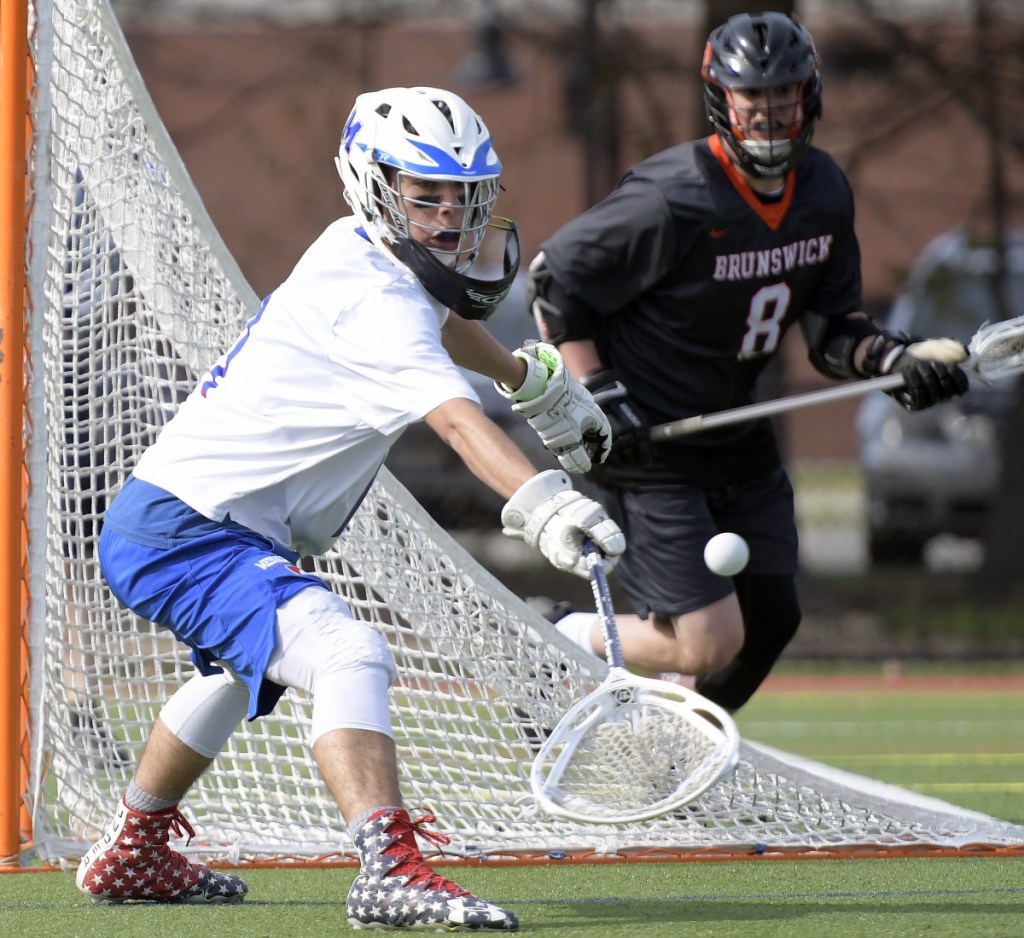 Messalonskee's Wade Carter grabs a shot as Brunswick's Garrett Woodruff closes in during a game Wednesday in Waterville.