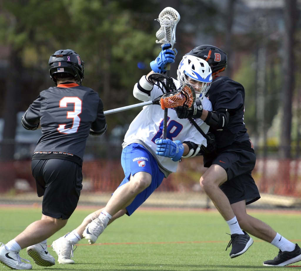 Messalonskee's Alden Balboni, center, crashes through Brunswick's defense during a game Wednesday in Waterville.