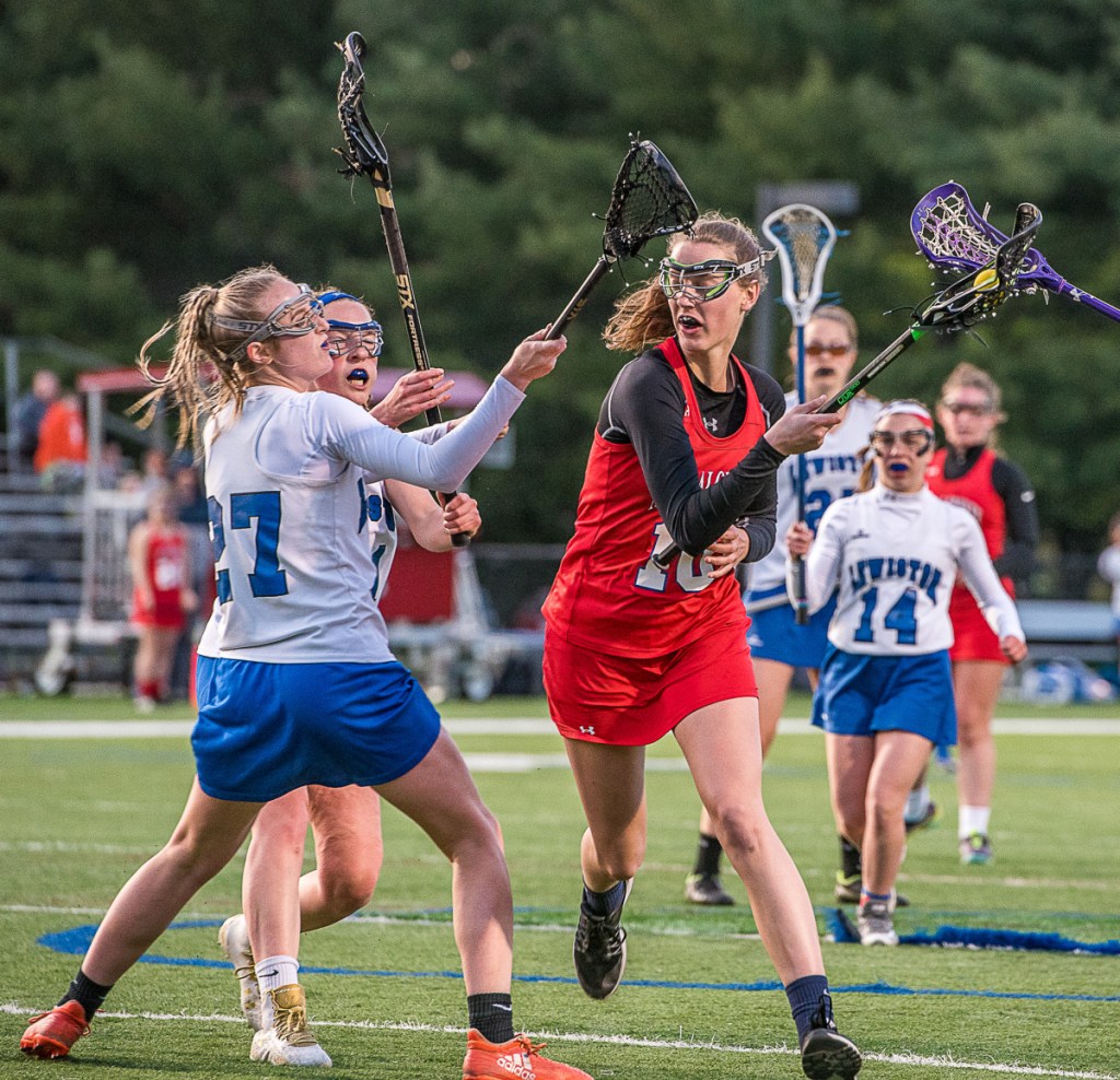 Messalonskee's Katie Seekins maneuvers past Lewiston's Kelsie Lynch during Wednesday night's lacrosse game at Bates College in Lewiston.