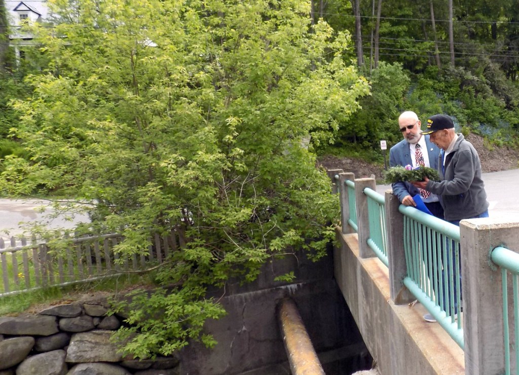 Sunday afternoon, Memorial Day Services were held in Wilton. Rep. Russell Black, R-Wilton, watches as World War II veteran Francis Palin prepares to drop a wreath over the bridge on Main Street.