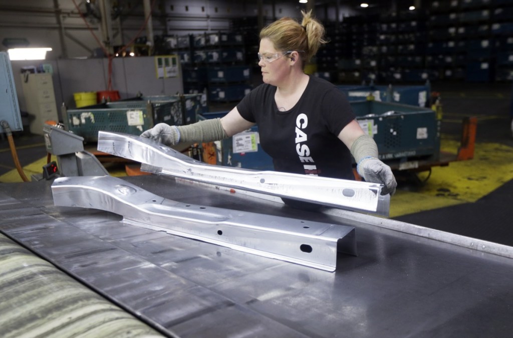 United Auto Workers line worker Crystal McIntyre unloads parts from a stamping machine at the General Motors Pontiac Metal Center in Pontiac, Mich.