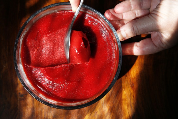 Christine Burns Rudalevige draws a scoop of strawberry sorbet. 