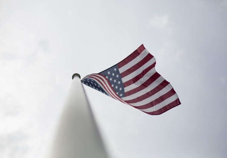 Visible from Ellen Peoples' garage, the American flag flaps in a breeze Wednesday. Peoples' son Alan says having a new flag and a place to fly it from remains an important part of his mother's life.