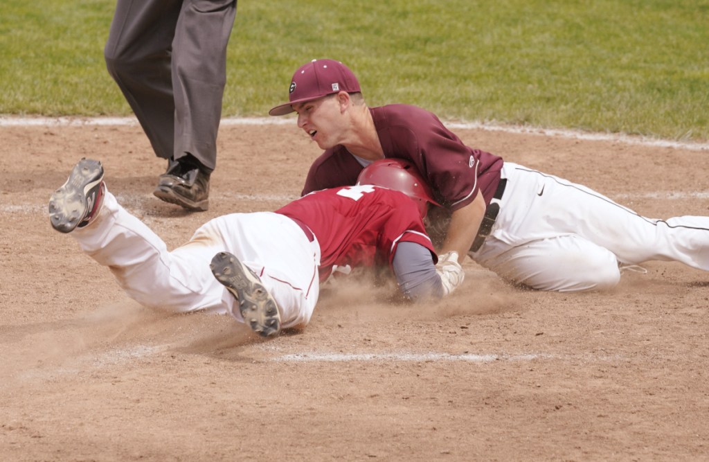 Bangor baserunner Zach Murray slides head first into home and into the chest of Gorham's Jacob Sladen during the Class A baseball final Saturday at St. Joseph's College in Standish. Murray was safe on the play.