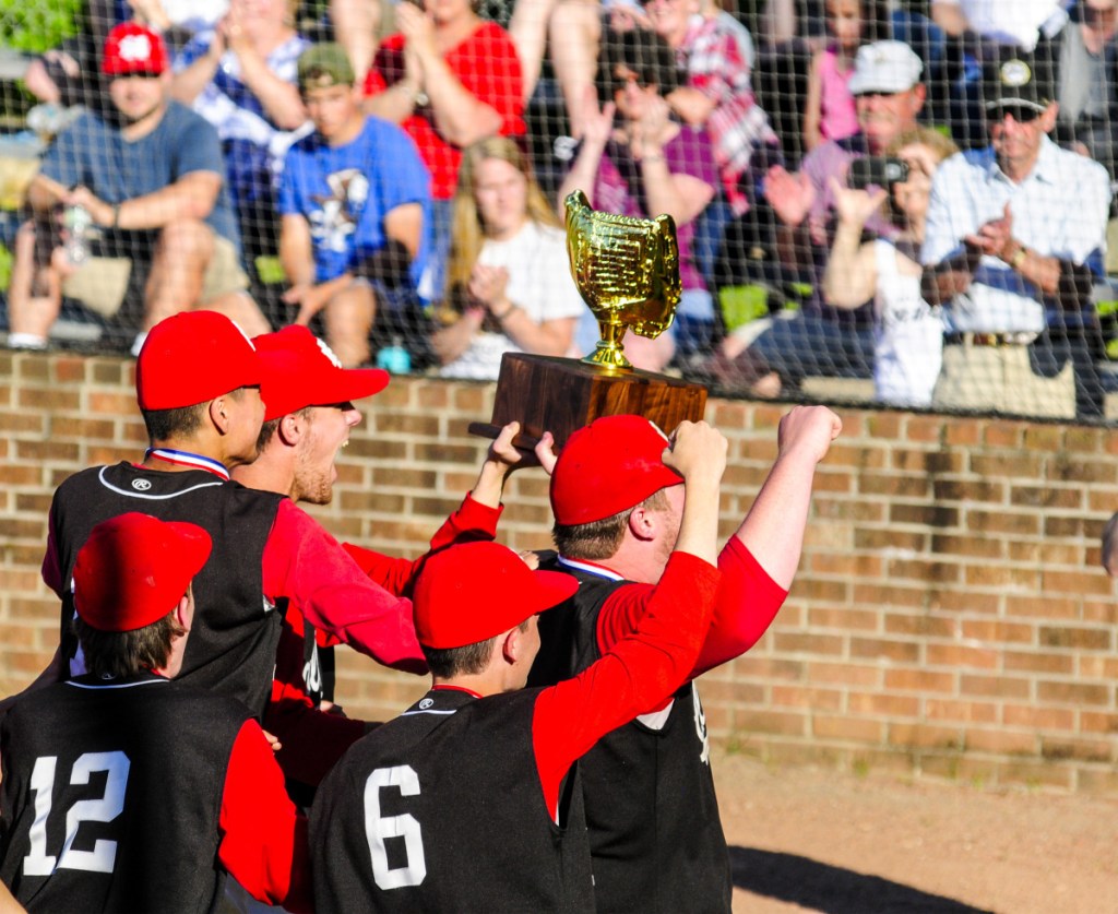 Members of the Hall-Dale baseball team carry the Class C state championship trophy after they defeated Houlton 2-1 at St. Joseph's College in Standish on Saturday afternoon.