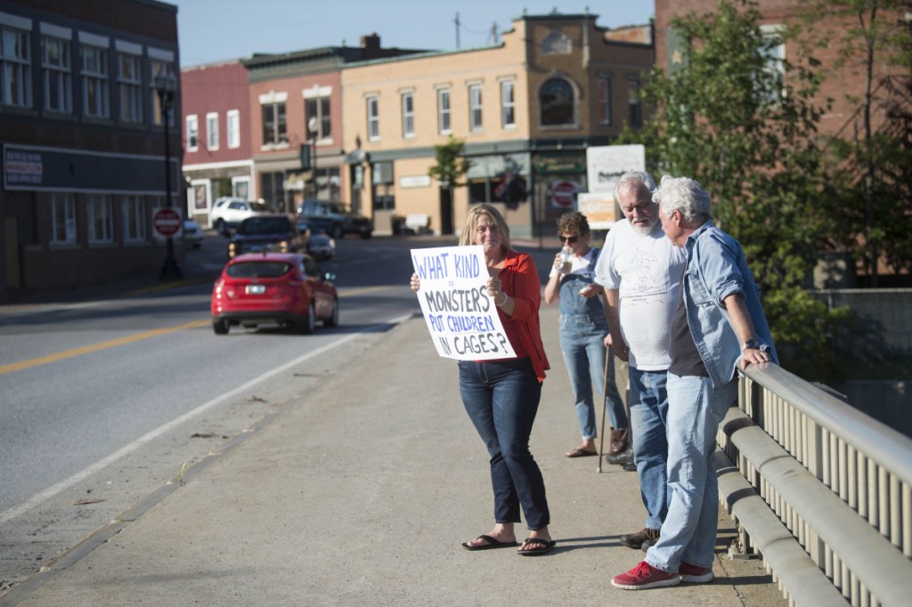 Hope Savage holds a sign Wednesday on the Margaret Chase Smith Bridges in Skowhegan in protest of the detention and separation of immigrant families along the Mexican border.
