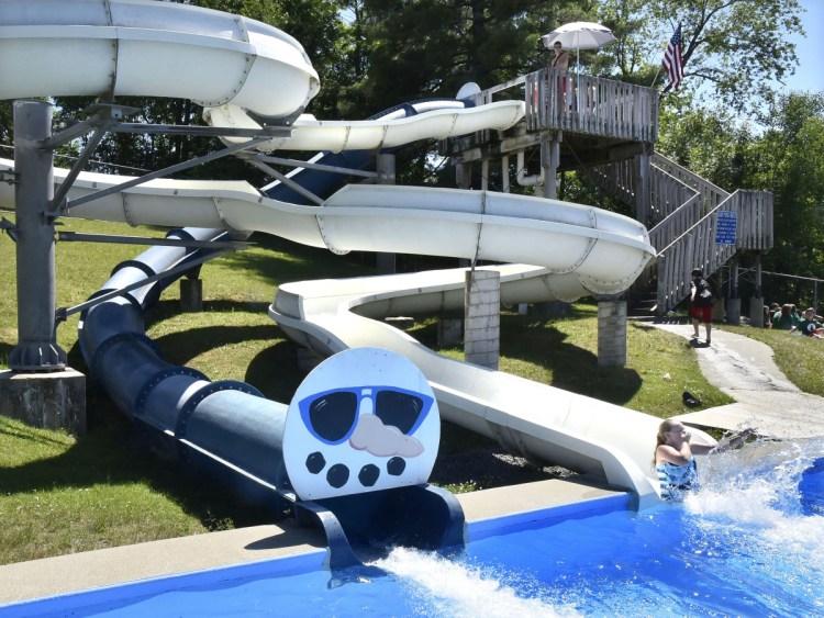 Serena Hotham blasts into a pool of water from one of two slides at the Alfond Municipal Pool in Waterville on June 26. Councilor Lauren Lessing says Mayor Nick Isgro wants to close the pool. Isgro says while he questions the use of money for slide repairs, he doesn't intend to close the pool.