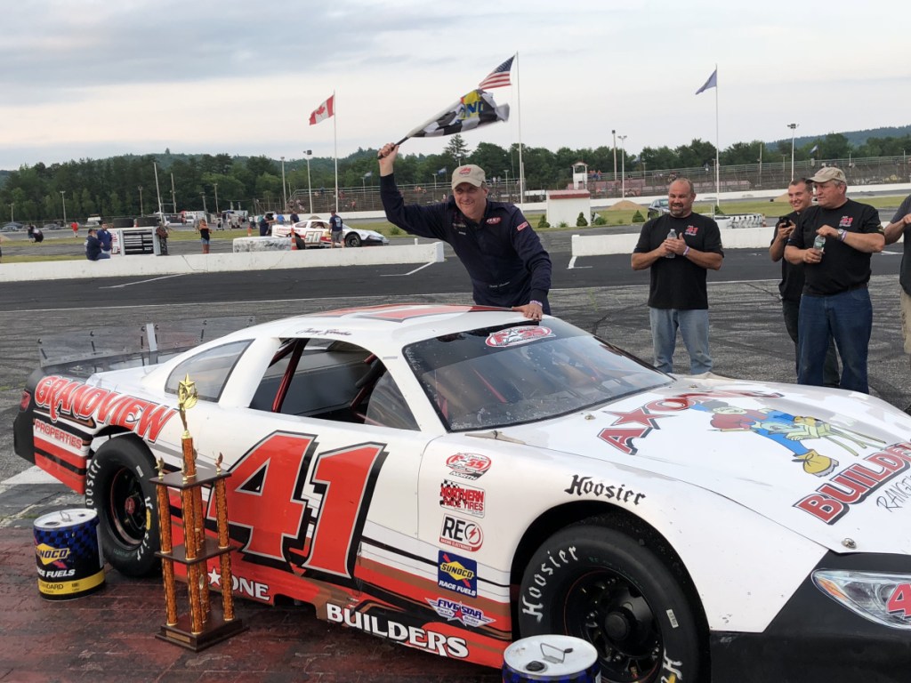 Tracy Gordon waves the checkered flag after winning the PASS Open 100 on Sunday at Oxford Plains Speedway.