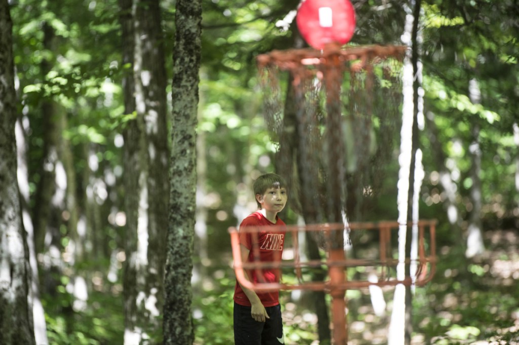 Nate Delisle, 11, sinks his putt during a Pro Disc Golf Association qualifier at Burnsboro Disc Golf Course on Saturday in Vassalboro.