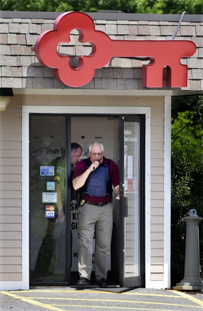 Waterville police Chief Joseph Massey exits the KeyBank branch on Kennedy Memorial Drive in Waterville shortly after it was robbed on Tuesday. Also investigating the armed robbery is Sgt. David Caron, at left. Police, guided by dispatchers tracking a GPS device secreted in the stolen money, immediately established a perimeter surrounding the position of the suspect and then tightened the loop around him.