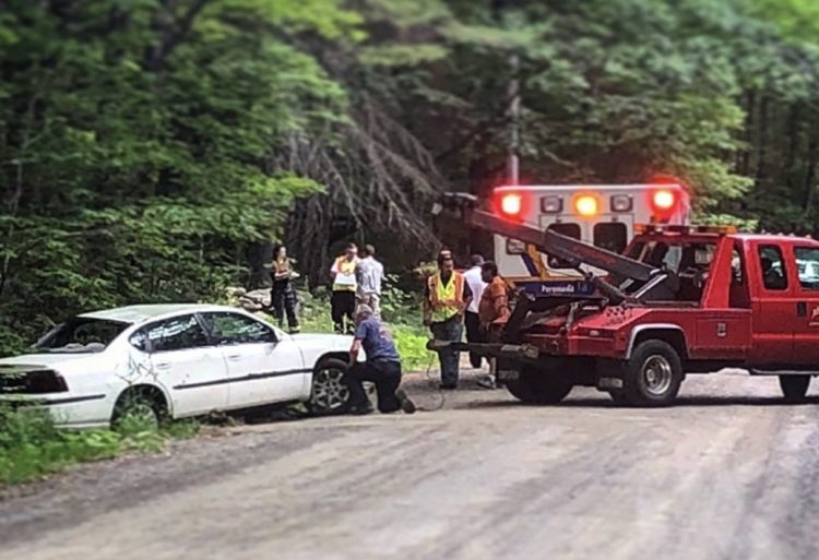 A crew works to pull a Chevrolet Impala out of a ditch Thursday morning on Wilder Hill Road in Smithfield after a crash. Kane Grondin, 17, who was driving the vehicle at the time of the crash, has been charged with imprudent speeding and carrying passengers with an intermediate license.