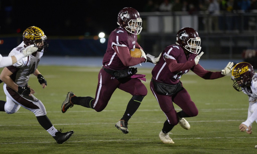 Maine Central Institute running back Adam Bertrand follows his blocker Pedro Matos during the Class C state title game last Noveber in Orono.