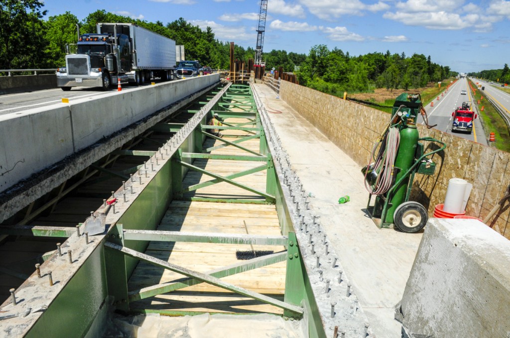 Wyman and Simpson employees work on re-decking an overpass that carries southbound traffic from Interstate 95's Exit 103 over the highway to the Interstate 295 toll booth on Wednesday in West Gardiner.