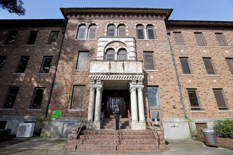 Q security officer stands on steps at the entrance to Western State Hospital on April 11, 2017, in Lakewood, Wash. Hundreds of mentally ill patients at Washington state's largest psychiatric hospital are forced to live in conditions that do not meet federal health and safety standards, while overworked nurses and psychiatrists say they must navigate a management system that punishes whistleblowers. 