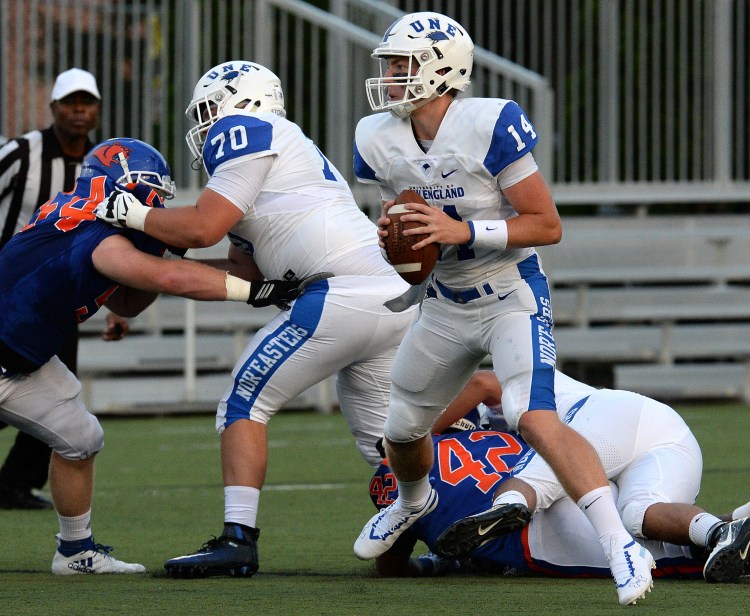 University of New England's quarterback Brian Peters runs out of the pocket and looks to pass during Thursday night's game.