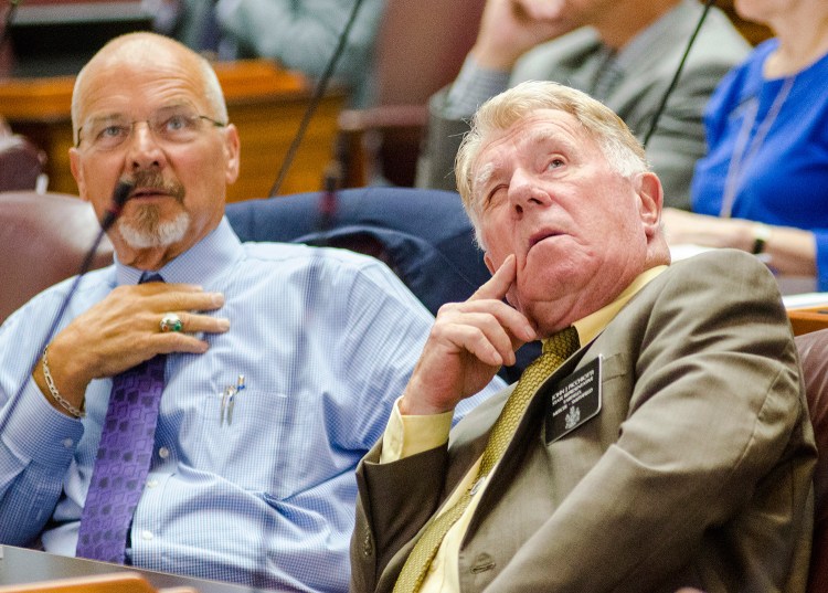 Reps. Larry Lockman of Amherst, left, and John Picchiotti of Fairfield look up at the vote tally boards in the corner of the House chamber Thursday.