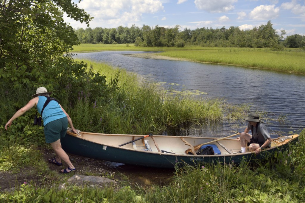 Suzanne and Gary Cole hoist a canoe Thursday at the boat launch on Annabessacook Lake on Waugan Road in Monmouth. Town selectmen have voted to close the boat ramp temporarily, pending a legal consultation. The Coles were surveying birds for the Maine Bird Atlas near their Monmouth home.