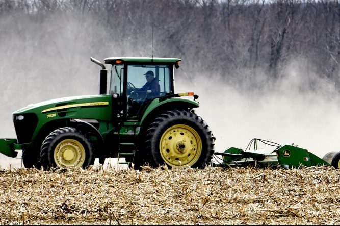 Dairy farmer Bussie York leaves a dusty trail as he chops corn stalks in a field at the Sandy River farm in Farmington on May 2. A proposal for a large solar farm involves his land.