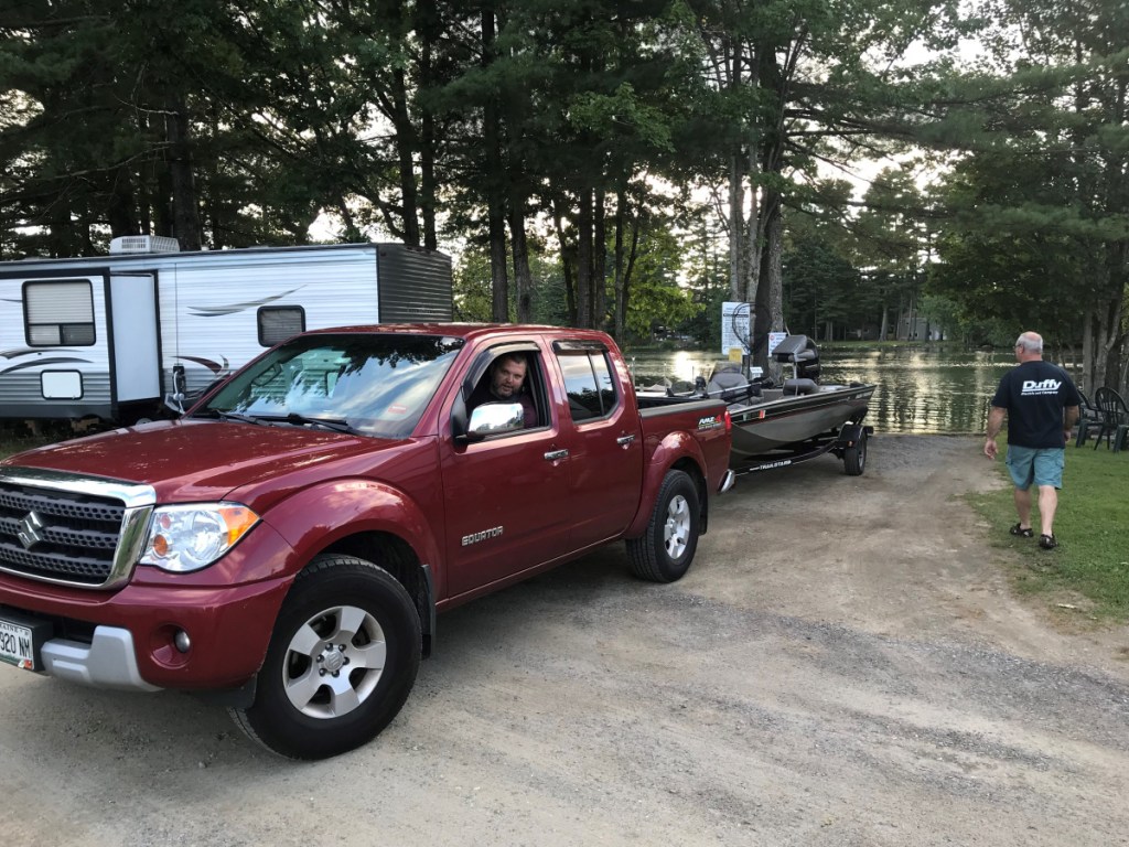 Erik Fitzsimmons, of Augusta, launches a boat Aug. 30 into Annabessacook Lake from Augusta West Kampground in Winthrop, as Mike Halligan, of Winthrop, watches. The owners of Augusta West Kampground have offered the use of their launch to the public after the town of Monmouth closed a ramp on Waugan Road over milfoil concerns.