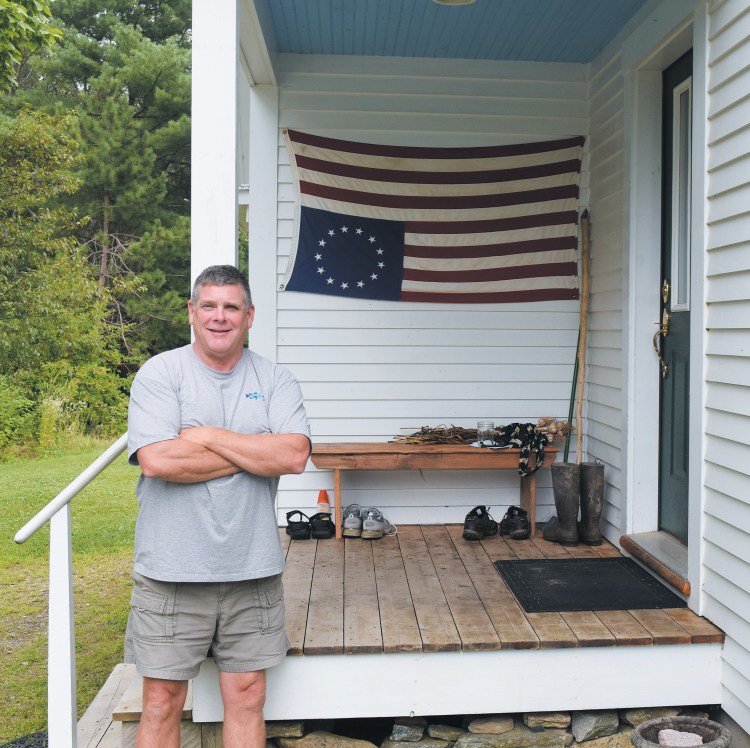 Bowdoinham resident Gregg McNally stands by the flag that has drawn attention from passers-by on Ridge Road. McNally said his intentions aren’t to disrespect the flag, but to signal what he sees as a state of distress in the nation. 