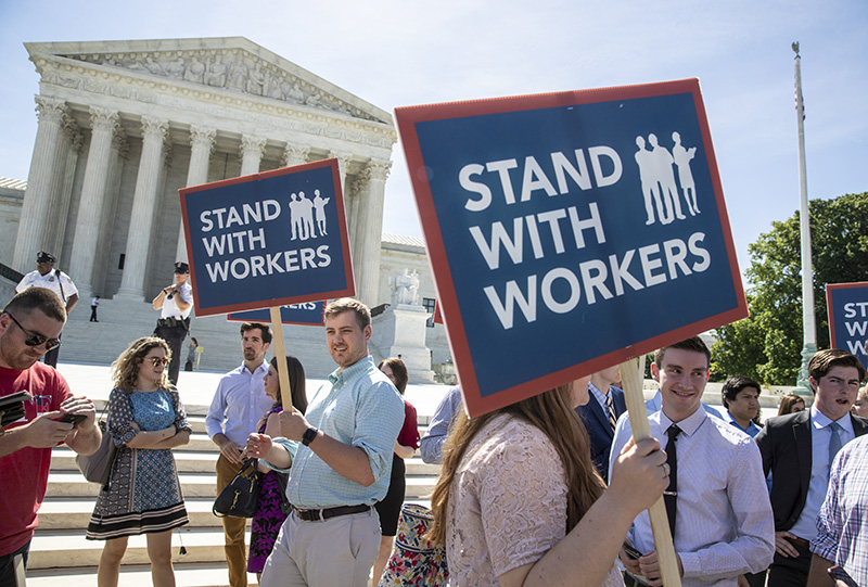 People gather on Monday at the Supreme Court awaiting a decision in an Illinois union dues case, Janus vs. AFSCME.