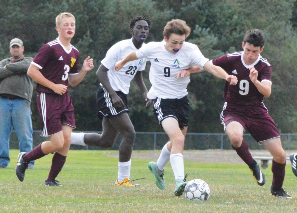 Pine Tree Academy's Evan Owen, center, tries to break away from Richmond's Mitch Couturier, right, during a Class D South game Thursday in Richmond. Looking on are Pine Tree's Chris Amisi (23) and Richmond's Ben Gardner (3).