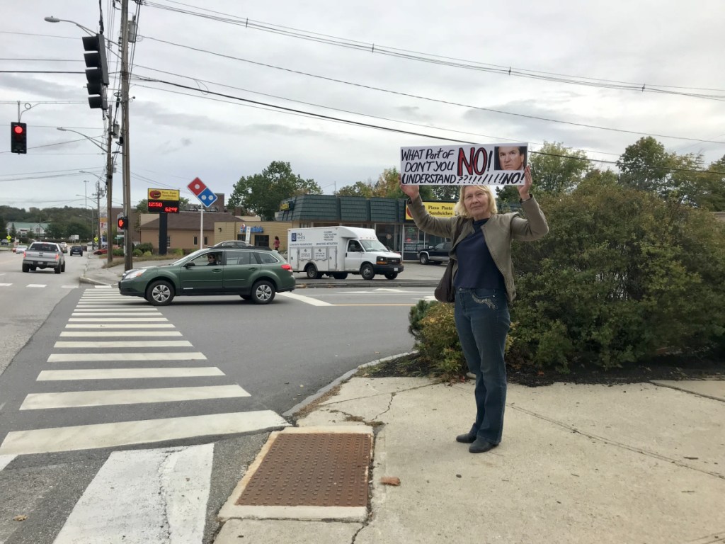 Bia Winter, of Mount Vernon, displays a sign protesting the potential confirmation of Judge Brett Kavanaugh as a Supreme Court justice on Friday afternoon outside U.S. Sen. Susan Collins's office at the Edmund S. Muskie Federal Building in Augusta.