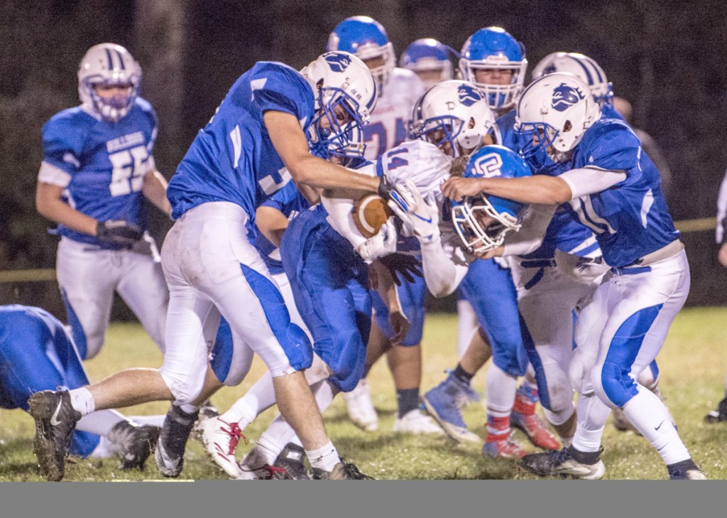 Oak Hill's Samuel Lindsay (14) gets smothered by Masdison defenders in the the first quarter Friday in Madison.