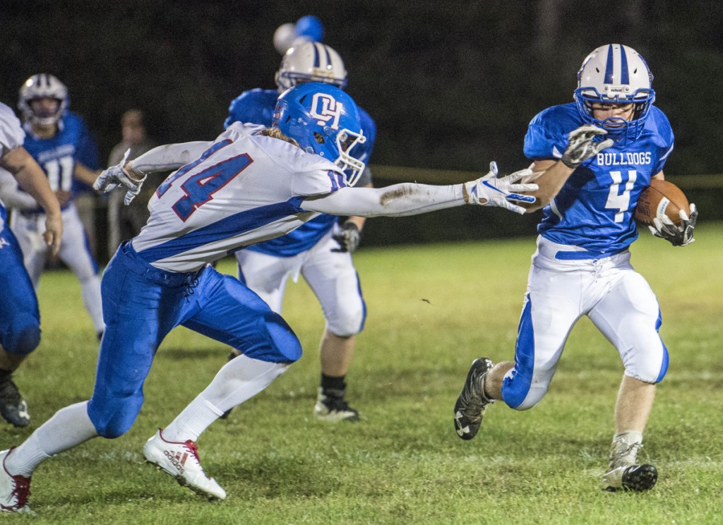 Madison's Josh Savage (4) runs by Oak Hill's Samuel Lindsay (14) in the first quarter Friday in Madison.