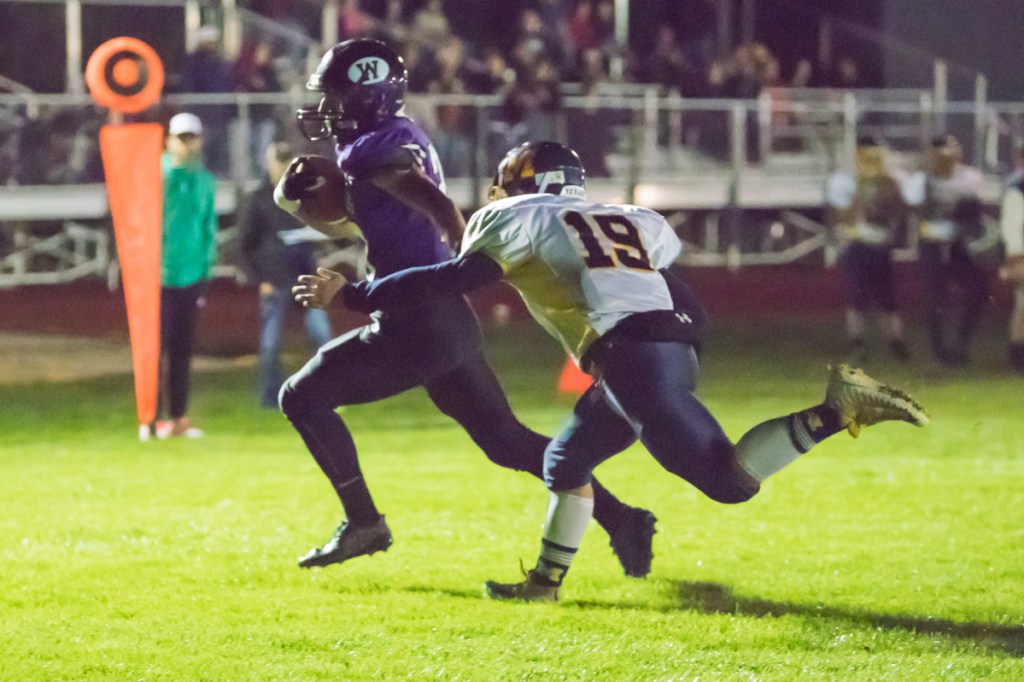Waterville's Nick Wildhaber scores a touchdown while Medomak's Eli Miller (19) tries to catch him Friday night in Waterville