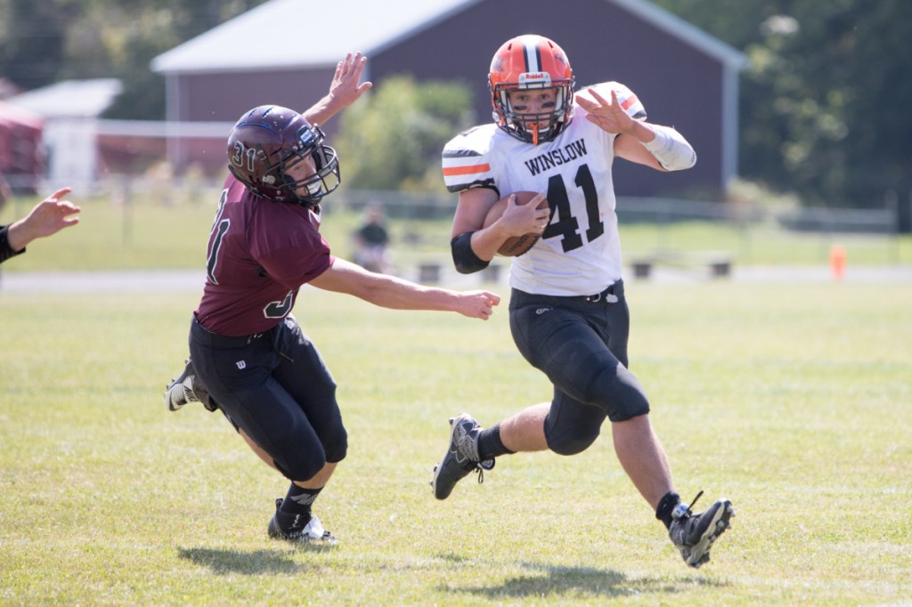 Winslow's Benjamin Dorval (41) carries the ball past Nokomis' Quinton Richards during a game Saturday in Newport.