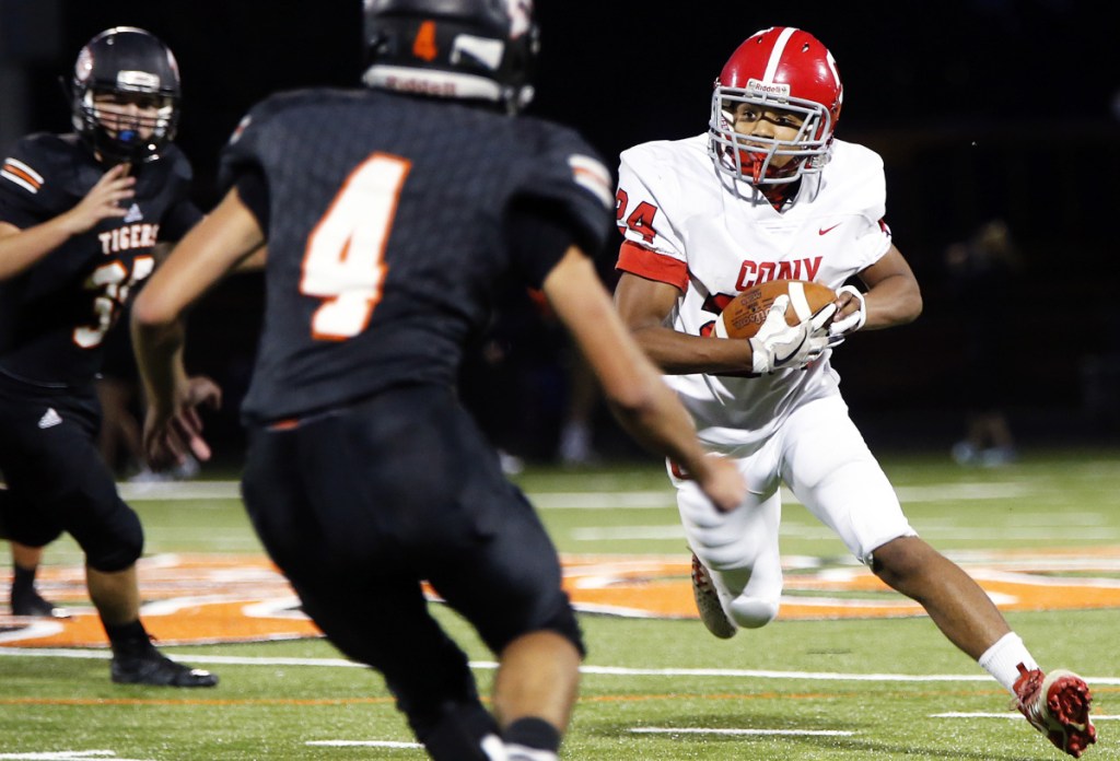 Portland Press Herald photo by Ben McCanna 
 Cony's Jamal Cariglia looks for a way around Biddeford's Ashton Crowell (4) during a game Friday night in Biddeford.