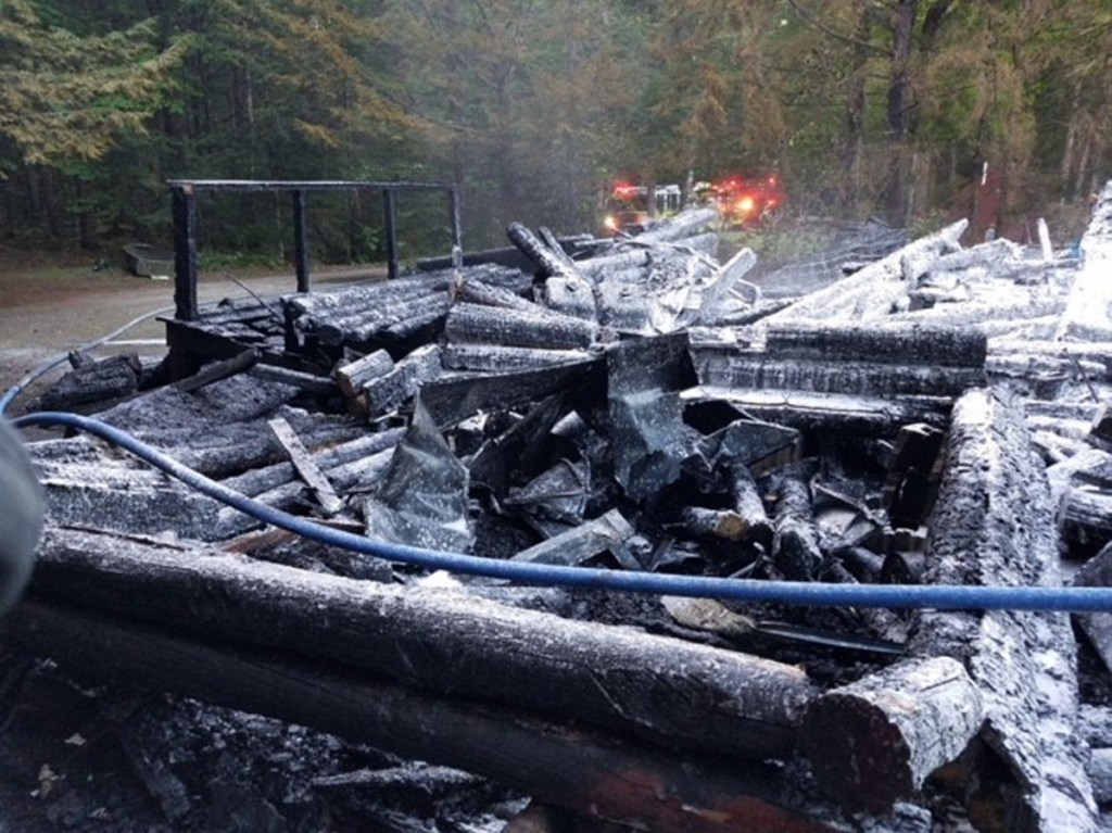 A log cabin camp on Hancock Pond in Embden that burned to the ground on Sunday, was started by a wood stove. No one was injured, but photographs of the family who has owned the camp for decades were destroyed.