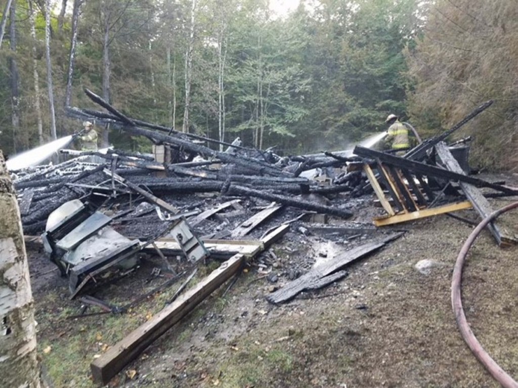 A log cabin camp on Hancock Pond in Embden that burned to the ground on Sunday, was started by a wood stove. No one was injured, but photographs of the family who has owned the camp for decades were destroyed.
