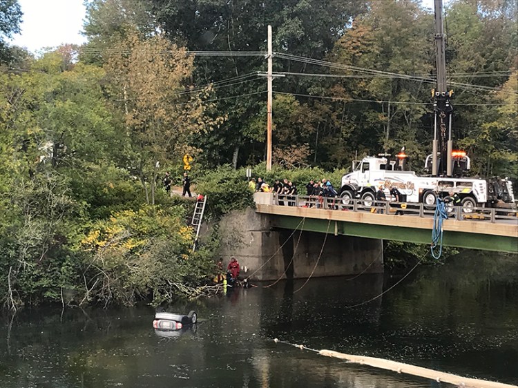 Officials at the Presumpscot River where a car was found floating Thursday morning.